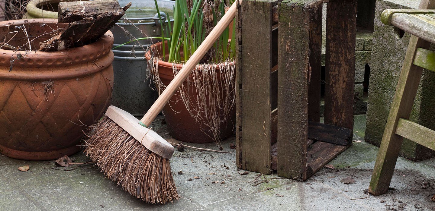 Broom outside near potted plants